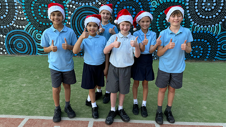 Six kids standing in the playground wearing Christmas hats