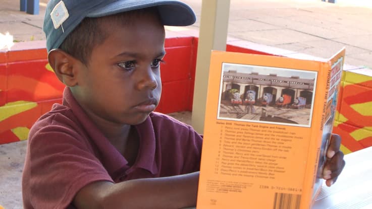 Boy reading a book in Katherine