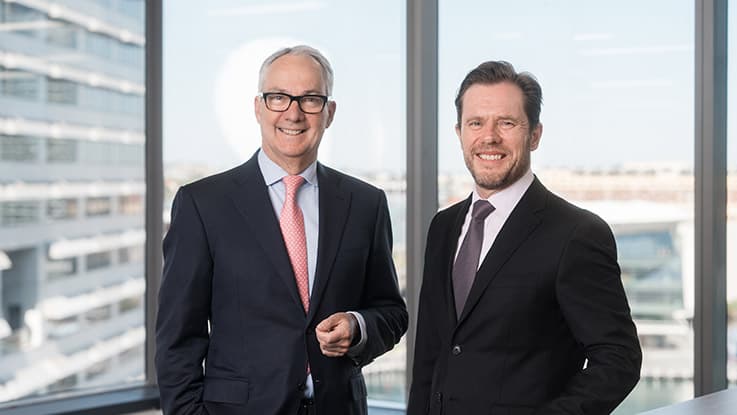 two business men wearing a suit smiling