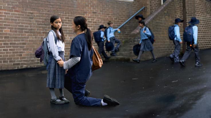 Leah standing with her mum in the playground