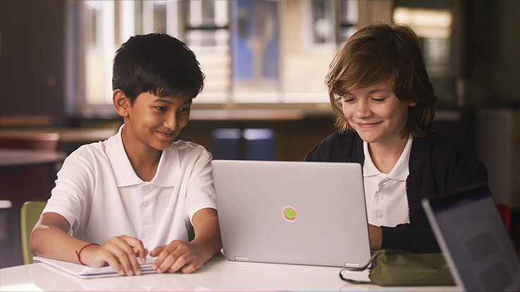 boys with laptop in library