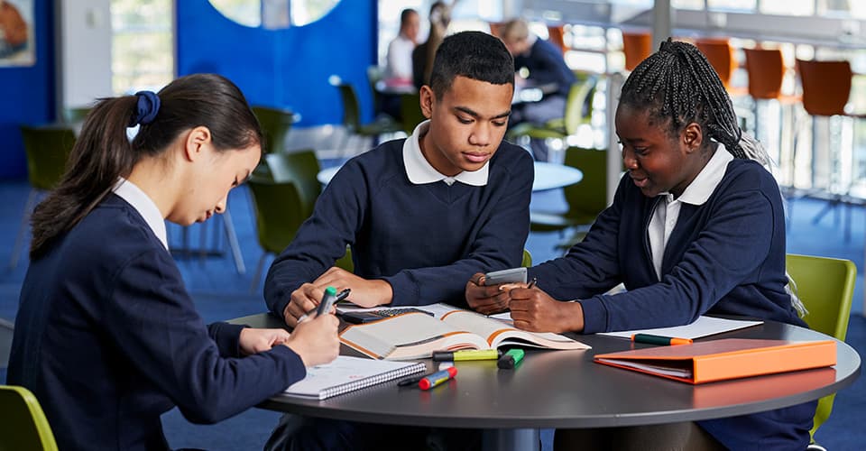 students in classroom using stationary working together