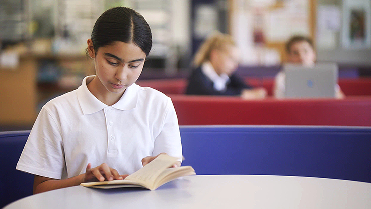 Student in a library reading a book