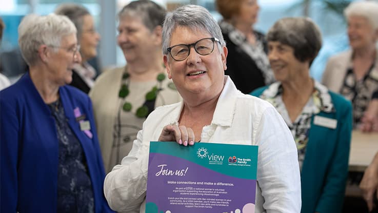 a lady holding a sign to join view club