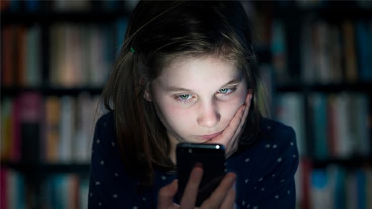 girl looking sad while staring at her mobile phone