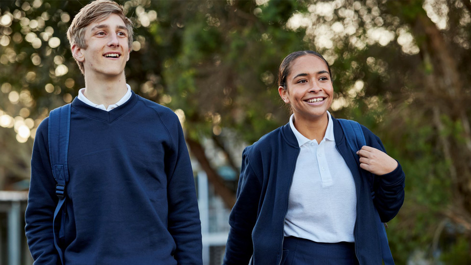 boy and girl wearing a school uniform walking