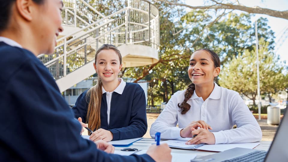 3 girls wearing school uniforms using the computer