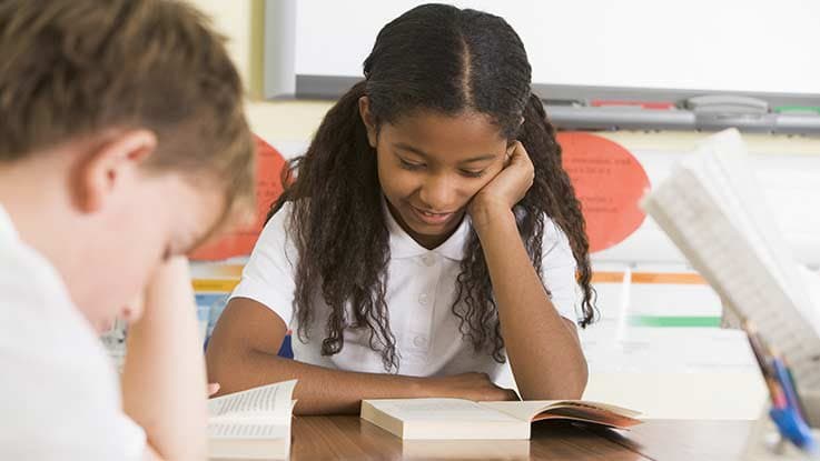 Girl working at her desk with classmate