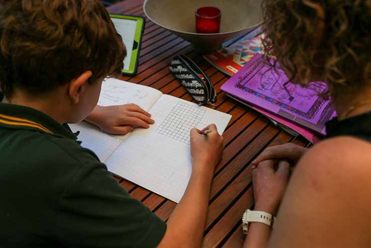 A child and adult learning at a desk