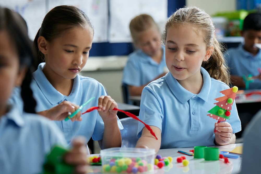 students in school uniform doing art workshops in classroom